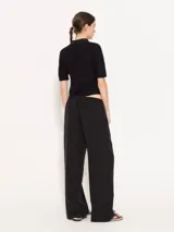 Pantalón negro de tencel con lino, de corte recto y caída liviana. Tiene elástico en la cintura, falsa cartera, bolsillos escondidos en el delantero y bolsillo ojal en la espalda.