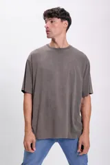 Remera gris oscuro de corte oversize, con cuello redondo y mangas cortas.