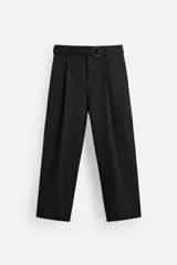 Pantalón negro de corte ancho con cinturón de tela con hebilla metálica y pliegues frontales.