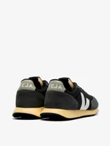 Championes Veja modelo Rio Branco, con capellada de malla técnica negra y superposiciones de gamuza gris. Logo lateral en forma de "V" color blanco.