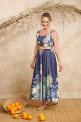 Vestido midi azul con estampado de palmeras y otros motivos tropicales, escote redondo y cinto de rafia.
