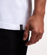 Musculosa blanca de algodón con cuello redondo y corte clásico.