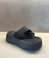 Sandalias negras tipo ojotas con plataforma gruesa y suela con dibujo.