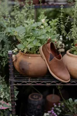 Mocasines marrones de cuero con elásticos laterales y tirador trasero.