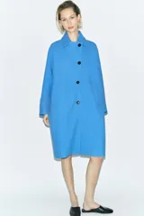 Abrigo amplio de Zara Woman Collection confeccionado en hilatura con mezcla de lana. Tiene cuello solapa, manga larga, bolsillos delanteros, forro interior a contraste y cierre frontal con botones.