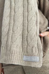 Bufanda marrón de tejido de punto industrial con diseño de ochos cruzados.