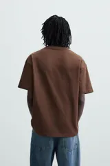 Camiseta marrón de algodón, corte relaxed fit, cuello redondo y manga corta.
