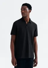 Camisa polo de piqué negro con cuello clásico y tapeta de dos botones.