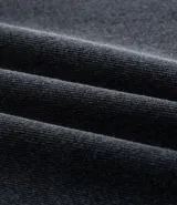 Pantalón de jean negro de corte baggy, con trabillas, bolsillos y cierre frontal con botón y cremallera. Fabricado con procesos más sostenibles y algodón certificado BCI.