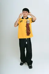 Chomba amarilla de piqué con cuello y puños negros, corte regular, bordado y aplique premium.