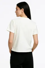 Remera blanca de algodón con estampado frontal con la frase "Ibiza is cheaper than therapy" en color bordó.