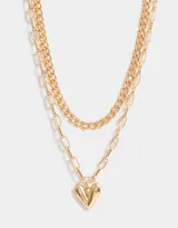 Collar corto dorado multicadena de metal con distintos eslabones y dije de corazón.