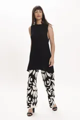 Pantalón ancho de tejido de punto, color amarillo claro con estampado floral grande en blanco.