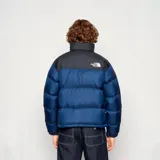 Campera puffer The North Face modelo 1996 Retro Nuptse 700, color azul con cuello negro, corte regular y logo bordado en blanco.