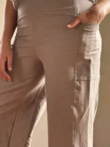 Pantalón palazzo color marrón claro, confeccionado en lycra de algodón, con tiro alto, bolsillos laterales y faja ancha en la cintura.