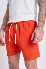 Short de baño color naranja con cintura elástica y cordón ajustable.