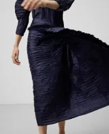Falda midi azul marino con textura arrugada y drapeado lateral.