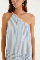 Vestido largo de rayas verticales celestes y blancas, con un solo tirante fino en el hombro izquierdo y corte asimétrico con volantes en la falda.