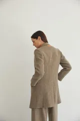 Tapado corto entallado color marrón claro con textura de espiga, cuello solapa y manga larga. Cierre frontal con botones.