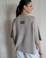 Sweater color beige de tejido de punto con mangas cortas y cuello redondo.