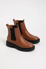 Botas Chelsea color marrón de cuero sintético, con elástico lateral negro, suela track negra y tirador trasero.