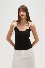 Musculosa negra con breteles finos, escote en V, punto smock y lazos en los hombros.