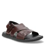 Sandalias de cuero marrón con tiras cruzadas y ajuste con velcro en el tobillo.