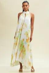 Vestido midi blanco con estampado floral en tonos verdes y amarillos. Diseño plisado con cuello halter y abertura en el pecho.