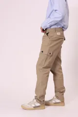 Pantalón cargo color beige con bolsillos laterales con solapa y cierre de botón a presión.
