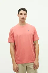 Remera de manga corta color salmón con logo bordado en el pecho.