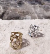 Anillo dorado con diseño abstracto con aberturas.