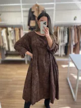 Vestido largo de pana fina color verde con estampado de flores marrones, corte oversize, mangas 3/4 y bolsillos laterales.