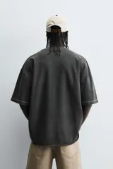 Camiseta color beige de corte holgado, cuello redondo y manga corta.