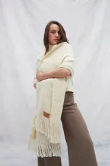 Chal de tejido liviano confeccionado en lana 100% sin teñir, color marrón, con detalle de flecos en los extremos.