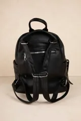 Mochila negra de cuero sintético con diseño minimalista, formato compacto y estructura blanda. Incluye bolsillo delantero con broche y cierre metálico superior con tiradores largos.