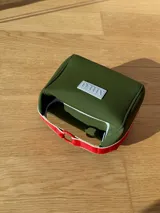 Neceser color beige de forma rectangular, con cierre superior y asa de mano.