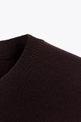 Top color crema de tejido de punto liso, con cuello redondo y mangas cortas.