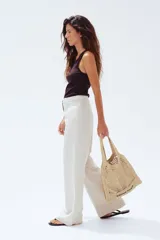 Pantalón sastrero color crema en tejido liviano de mezcla de lino y viscosa con pinzas adelante y atrás. Modelo de tiro alto con cierre, botón nacarado y piernas amplias.