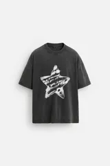 Camiseta negra con efecto lavado, cuello redondo, manga corta y estampado de estrella con texto en el centro.
