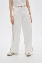 Pantalón jean de calce ancho y tiro alto, con diseño color block en tonos blanco y beige.