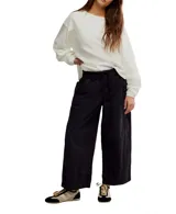 Pantalón negro amplio de algodón, con cintura elástica ajustable con cordón y bolsillos laterales.