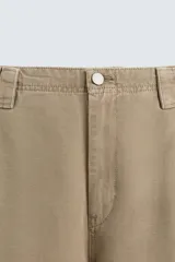 Pantalón cargo color beige, de corte relaxed fit, con bolsillos frontales, traseros con solapa y bolsillos laterales tipo parche con solapa.