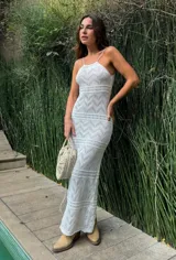 Vestido largo de tejido calado color blanco, con breteles finos y corte ajustado.