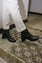 Botas cortas de cuero negro con cierre lateral y taco de madera.
