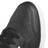 Championes Adidas Hoops 4.0 Mid de caña media, color negro con detalles en blanco. Confeccionados en cuero sintético con las tres tiras características de la marca en los laterales y suela de goma blanca.