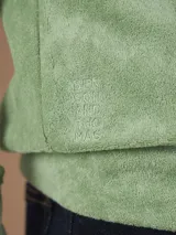 Campera con capucha de toalla de algodón color verde azulado, con cierre frontal y bolsillos laterales.