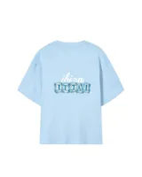 Remera celeste de corte holgado con estampado frontal de la frase "Ibiza Ittai" con letras que simulan cubos de hielo.