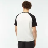 Camiseta blanca con mangas cortas raglán negras y logo pequeño en el pecho.