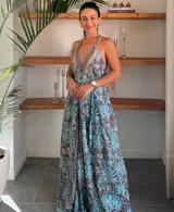 Vestido largo tipo solera, color turquesa con estampado paisley en tonos marrones y dorados. Diseño con escote halter anudado al cuello y abertura frontal central en color liso.