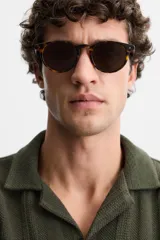 Camisa verde militar de manga corta con cuello bowling, corte relaxed fit y cierre frontal con botones.